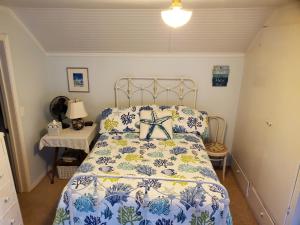 a bedroom with a bed with a blue and white comforter at Bay Cottage Getaway in Port Townsend +12 photos