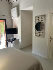 a bedroom with a bed and a desk and a mirror at Villa Le Petit Paradis Saly Boutique Hotel in Ngaparou