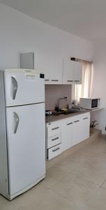 a kitchen with a white refrigerator in a room at Center Cruz del Eje in Cruz del Eje