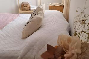 białe łóżko z 2 poduszkami i kwiatem w obiekcie Center Cruz del Eje w mieście Cruz del Eje