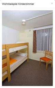 1 dormitorio con 2 literas y 1 silla en Bungalow WALD & SAND direkt am Strand en Dranske