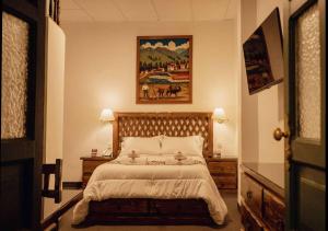 1 dormitorio con 1 cama y una pintura en la pared en El Portal Del Marques en Cajamarca