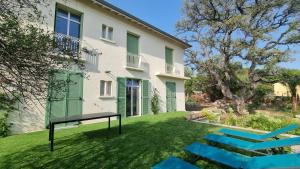 a house with a bench in the yard at Vacances en Famille ou entre Amis in Saint-Raphaël