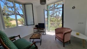 ein Wohnzimmer mit einem Sofa, einem Tisch und Fenstern in der Unterkunft Vacances en Famille ou entre Amis in Saint-Raphaël