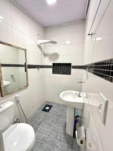 a bathroom with a toilet and a sink and a mirror at Recanto da Vera in Ilhabela