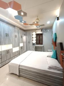 a bedroom with a large bed and a ceiling at Stay daily Inn in Varanasi