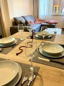 a wooden table with plates and wine glasses on it at Compass Lofts Athens in Athens