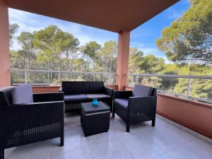 een afgeschermde veranda met stoelen en een tafel bij Precioso apartamento en la playa de Pals con piscina - Recinto Puig Sa Guilla in Pals