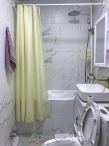 ein Badezimmer mit einem gelben Duschvorhang und einem WC in der Unterkunft Bolod Guesthouse and Tours in Ulaanbaatar