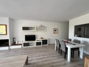 sala de estar con mesa de comedor y TV en Precioso apartamento en la playa de Pals con piscina - Recinto Puig Sa Guilla, en Pals