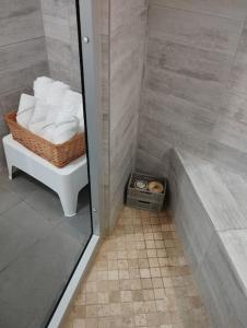 La salle de bains est pourvue d'une douche et d'un panier de serviettes. dans l'établissement Maison 115 m 2 avec Jardin, à Carignan