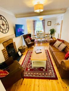 a living room with a couch and a coffee table at Gorwel, Spacious 3 Bedroom Cottage near the Beach in Llanarth