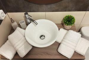 a bathroom sink with white towels and a plant at Compass Lofts Athens in Athens