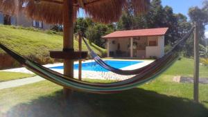 uma rede em frente a uma casa com piscina em chácara Santa luzia em Monte Alegre do Sul