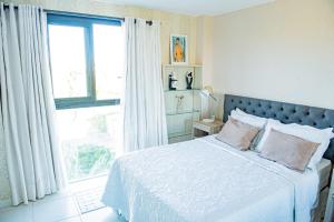 a bedroom with a bed and a large window at Condominio Iberostate in Praia do Forte