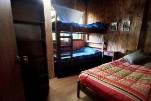1 dormitorio con 2 literas y 1 cama en Acogedora cabaña en Caburgua, en Pucón