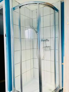a shower with a glass enclosure in a bathroom at Gorwel, Spacious 3 Bedroom Cottage near the Beach in Llanarth
