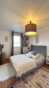 ein Schlafzimmer mit einem großen Bett und einer großen Lampe in der Unterkunft Charmant T2 au Cœur de Montigny-lès-Cormeilles in Montigny-lès-Cormeilles