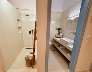 een witte badkamer met een wastafel en een toilet bij Afroditi Junior Suites in Archangelos