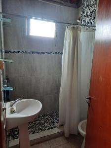 een badkamer met een wastafel en een douchegordijn bij ROMFER II in San Eduardo del Mar
