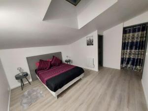 ein Schlafzimmer mit einem Bett mit einer lila Decke in der Unterkunft Appartement en duplex A113 in Draveil