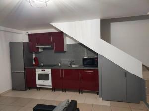 eine Küche mit roten Schränken und einer weißen Arbeitsplatte in der Unterkunft Appartement en duplex A113 in Draveil