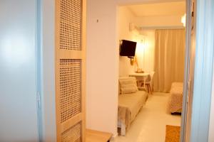 a room with a bedroom with a bed and a television at Afroditi Junior Suites in Archangelos