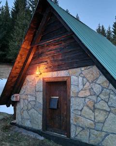 Cette petite cabine est dotée d'une porte en bois et d'un mur en pierre. dans l'établissement Katun VRELA - Vergaševići, à Bijelo Polje