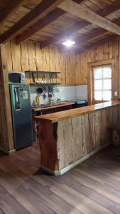 eine Küche mit einem Kühlschrank und einer Theke in einer Hütte in der Unterkunft Cabaña Río Iculpe in Lago Ranco