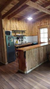 a kitchen with a refrigerator and a counter in a cabin at Cabaña Río Iculpe in Lago Ranco