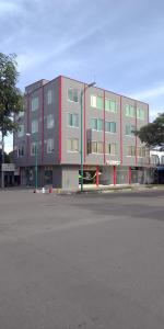 un gran edificio con un estacionamiento delante de él en HOTEL CANAGUARO GAITAN en Puerto Gaitán
