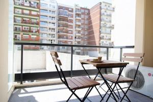 een tafel en 2 stoelen op een balkon met uitzicht bij Malvon Beautiful Suite in Buenos Aires