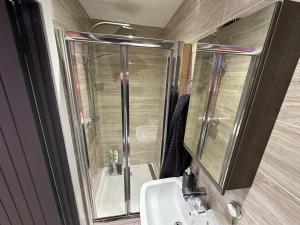 a bathroom with a sink and a shower with a mirror at New York wicker in Sheffield