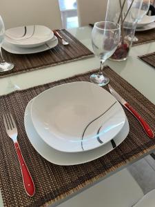 stół z białą płytą oraz czerwonym nożem i widelcem w obiekcie Casa Giuly w mieście Caleta De Fuste