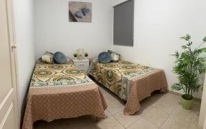 dwa łóżka siedzące obok siebie w pokoju w obiekcie Casa Giuly w mieście Caleta De Fuste