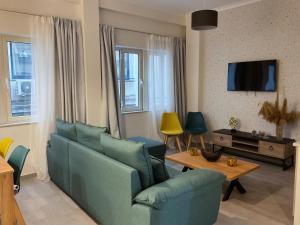 ein Wohnzimmer mit einem blauen Sofa und einem TV in der Unterkunft Compass Lofts Athens in Athen