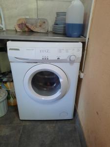 een wasmachine en droger in een keuken met een plank bij ROMFER II in San Eduardo del Mar