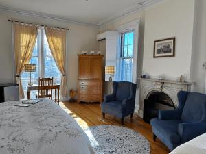 a bedroom with a bed and two chairs and a fireplace at Christopher Dodge House in Providence