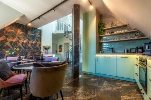 a kitchen with blue cabinets and chairs and a table at Villa Viktória in Balatonfüred