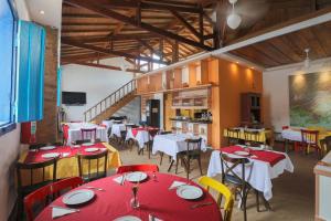 a restaurant with tables and chairs with red and yellow chairs at Hotel Porto do Ribeirão in Iporanga