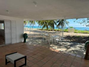 un patio con tavolo, sedie e spiaggia di Casa Pê na Areia e Vista ao Mar em São José a São José da Coroa Grande