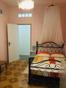 a bedroom with a bed with a window and a door at Villa Coquelicot in Rivière-Pilote