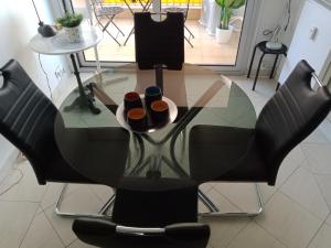 a glass table with two bottles on top of it at APPARTEMENT AU CALME in Menton