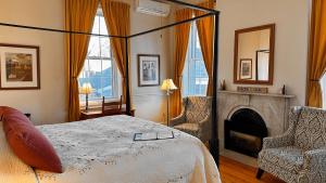 a bedroom with a bed and two chairs and a fireplace at Christopher Dodge House in Providence
