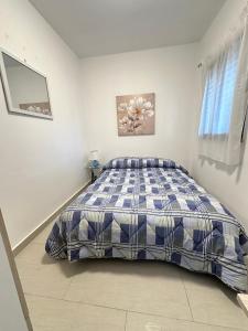 Schlafzimmer mit einem Bett mit einer blauen und weißen Bettdecke in der Unterkunft Casa mamma Etna in Zafferana Etnea