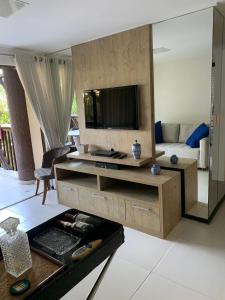 uma sala de estar com uma televisão e um sofá em Barra Bali Beach Service 323 BARRA DE SÃO MIGUEL na Barra de São Miguel