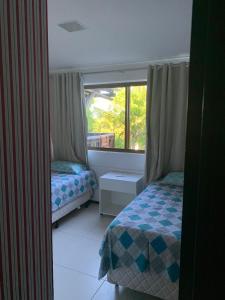een slaapkamer met 2 bedden en een raam bij Barra Bali Beach Service 323 BARRA DE SÃO MIGUEL in Barra de São Miguel