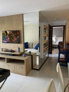 uma sala de estar com um sofá e uma televisão em Barra Bali Beach Service 323 BARRA DE SÃO MIGUEL na Barra de São Miguel