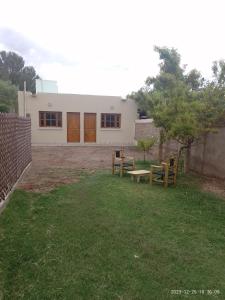 a house with two picnic tables in a yard at Alojamiento Huazhiul Barreal in Barreal