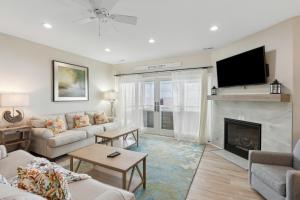 a living room with a couch and a fireplace at BeachZilla - 907 East Arctic in Folly Beach